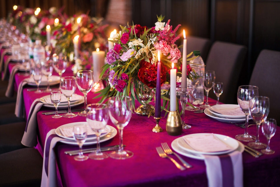 Elegantdarkpinkweddingbanquettablewithglassesdishesandflowersdecorationindoorsinrestaurant.Gorgeouslongweddingtable.Weddingdecorationconcept.Magentacolor-960×720